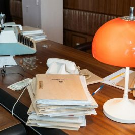 Bureau de travail style années 50-60, lampe orange, dossiers et machine à écrire. crédit photo : Mart Production Pexel