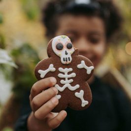 Enfant tenant dans sa main un biscuit en forme de squelette