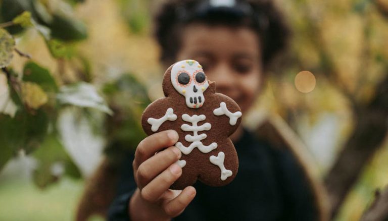 Enfant tenant dans sa main un biscuit en forme de squelette